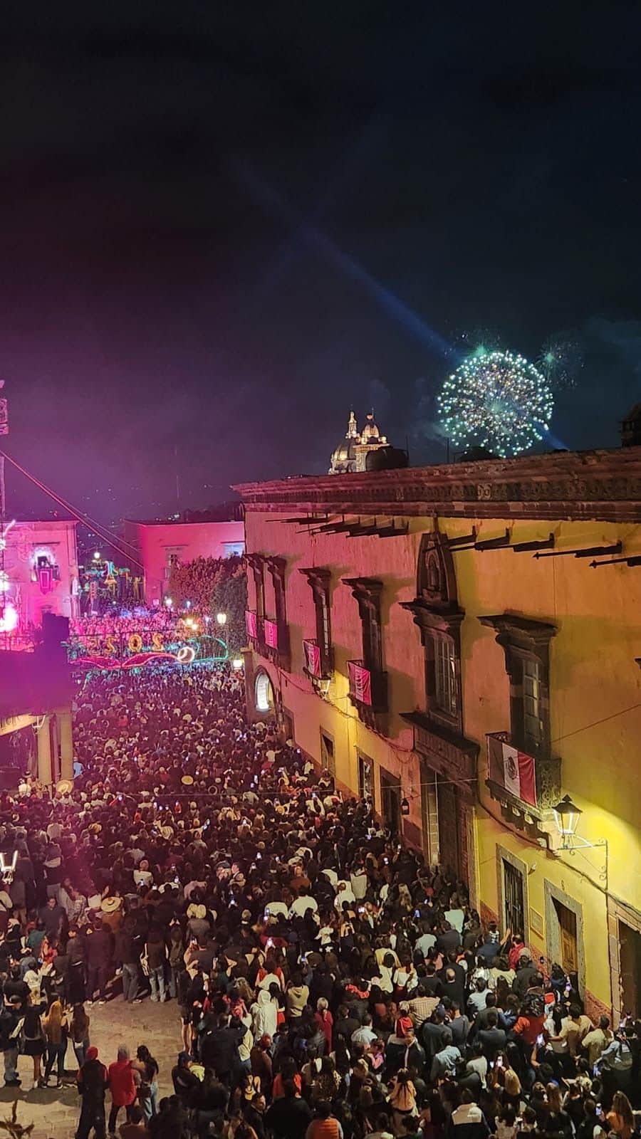 Fireworks over a crowded street during a festival in San Miguel de Allende