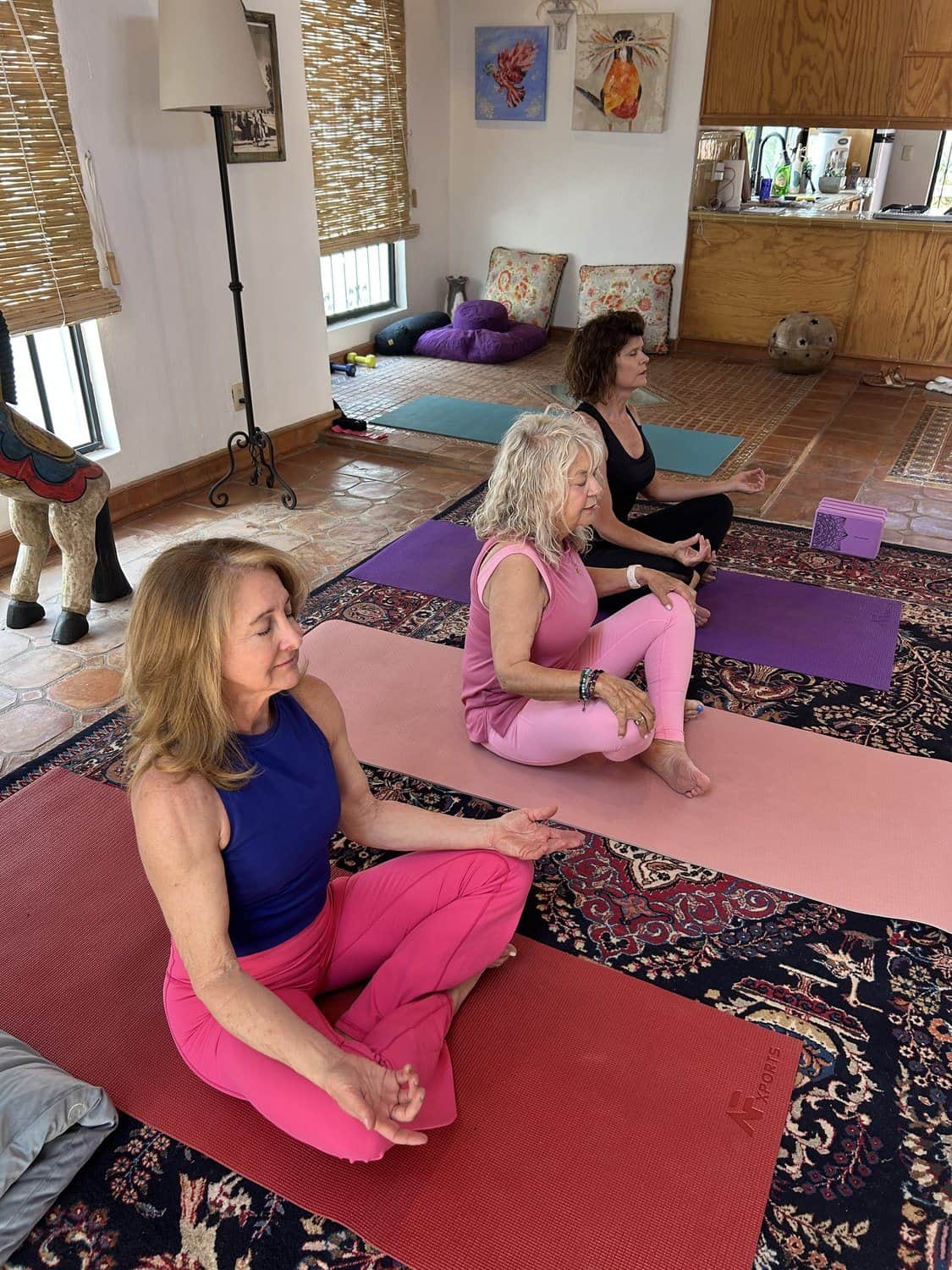 Alicia seated at the front of a small class, others practicing behind her